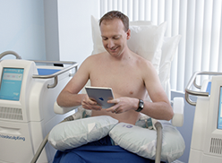A man watch a video on his iPad during a Coolsculpting treatment
